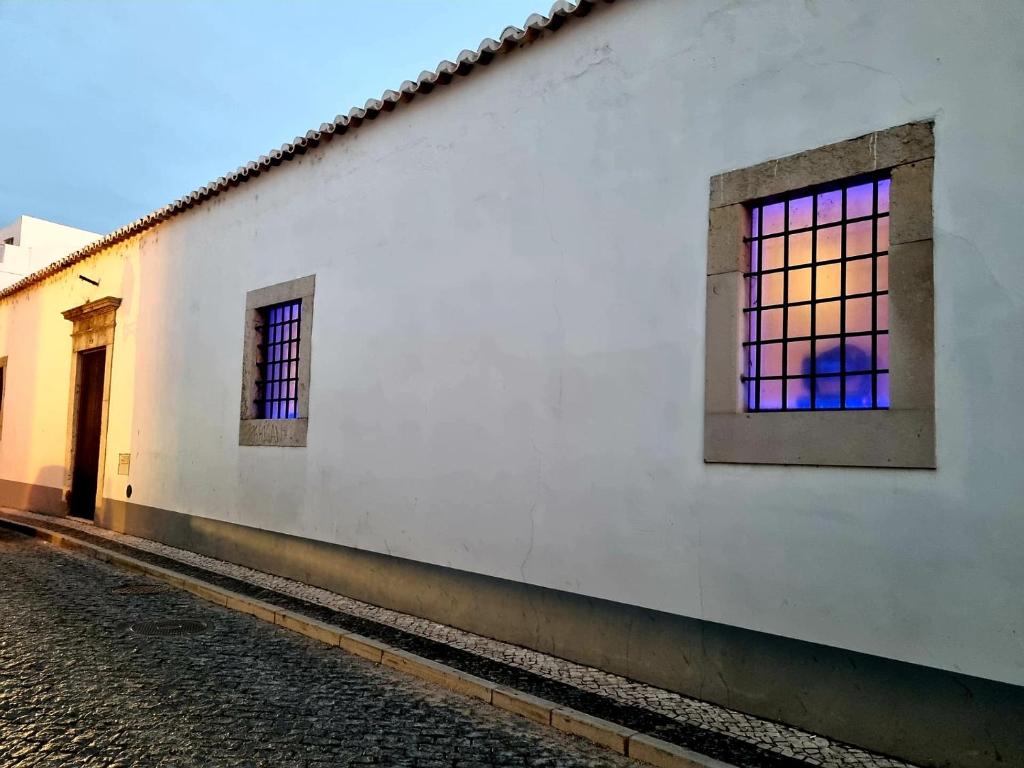 a white building with a stained glass window on it at Casa A Júlia In Faro's Heart in Faro