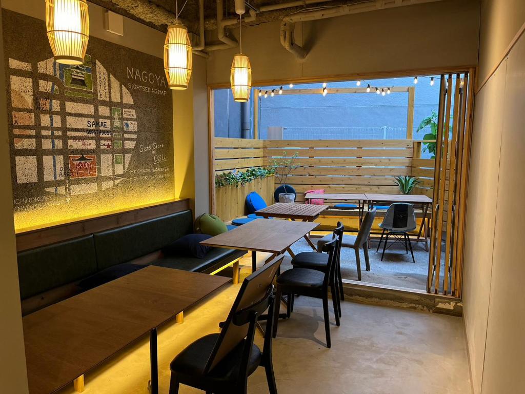 a restaurant with tables and chairs and a large window at 2023年6月開業 サカエ ゲストハウス in Nagoya