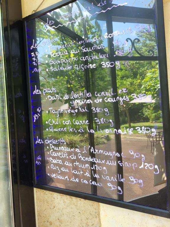 a sign on a window with writing on it at Hôtel La Flambée in Bergerac