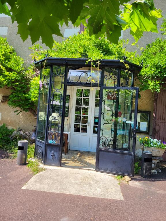 an entrance to a glass greenhouse with a door at Hôtel La Flambée in Bergerac