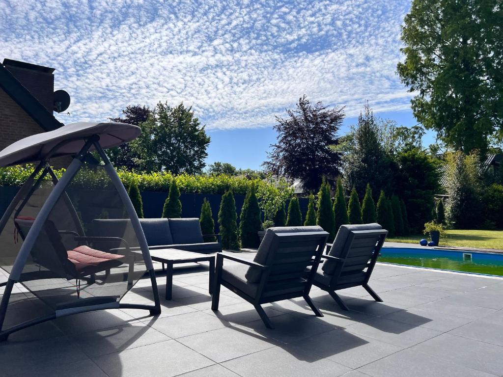 a patio with chairs and a table and an umbrella at LUXUS-RelaxDays-Apartments in Gütersloh