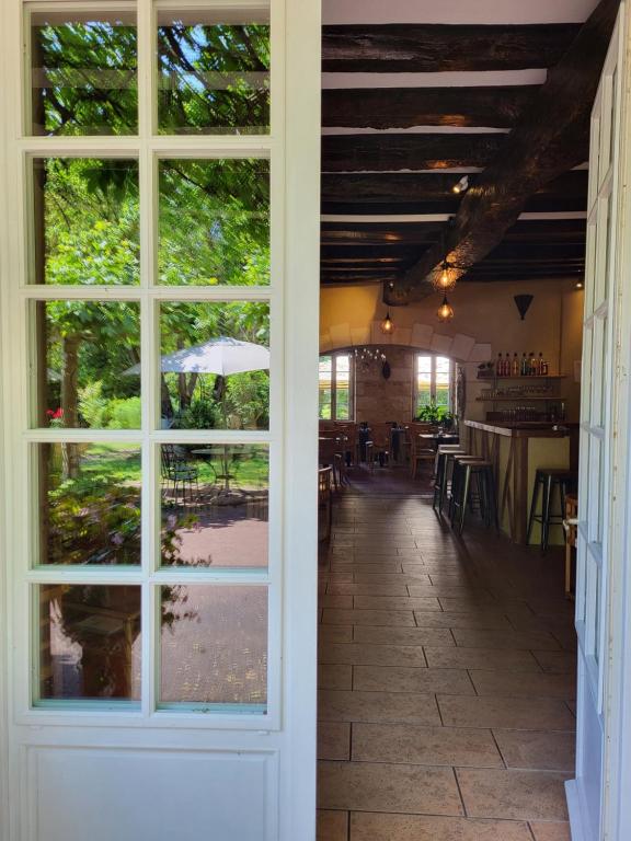 an open door to a restaurant with tables and chairs at Hôtel La Flambée in Bergerac