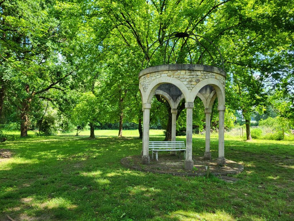 a park with a bench in the middle of a field at Hôtel La Flambée in Bergerac