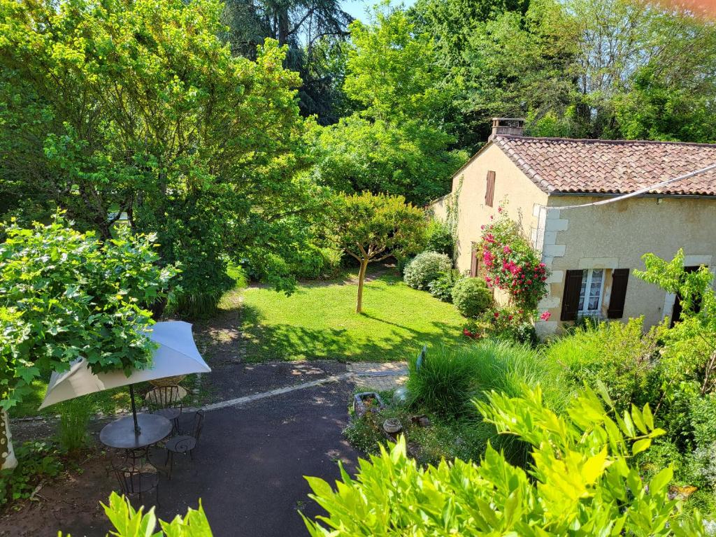 a view of a garden with a house at Hôtel La Flambée in Bergerac