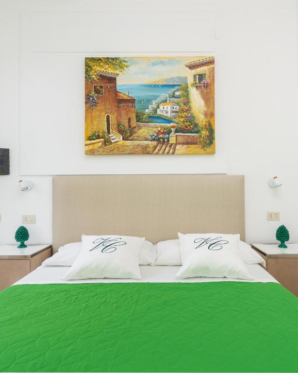 sypialnia z łóżkiem i obrazem na ścianie w obiekcie Villa Cristina - De Vivo Realty Piano di Sorrento w mieście Piano di Sorrento