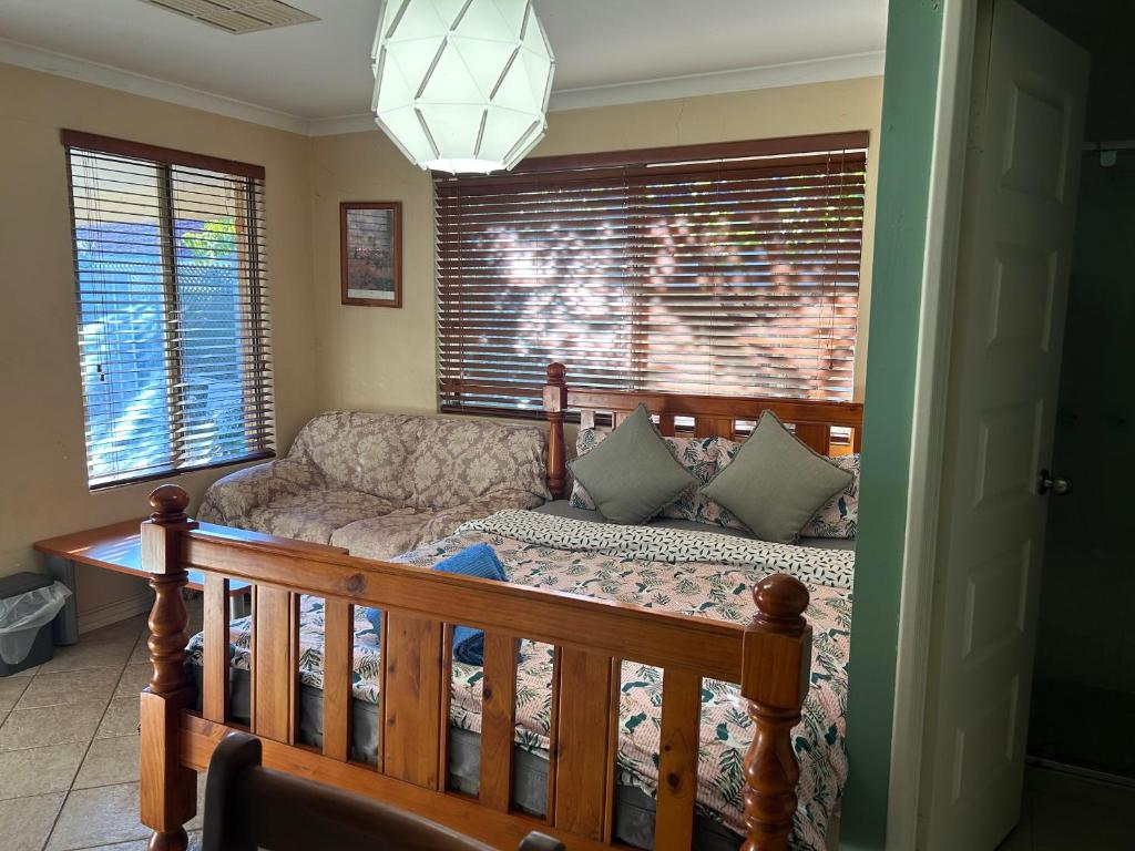 uma sala de estar com uma cama e um sofá em lovey studio with bathroom and kitchen em Perth