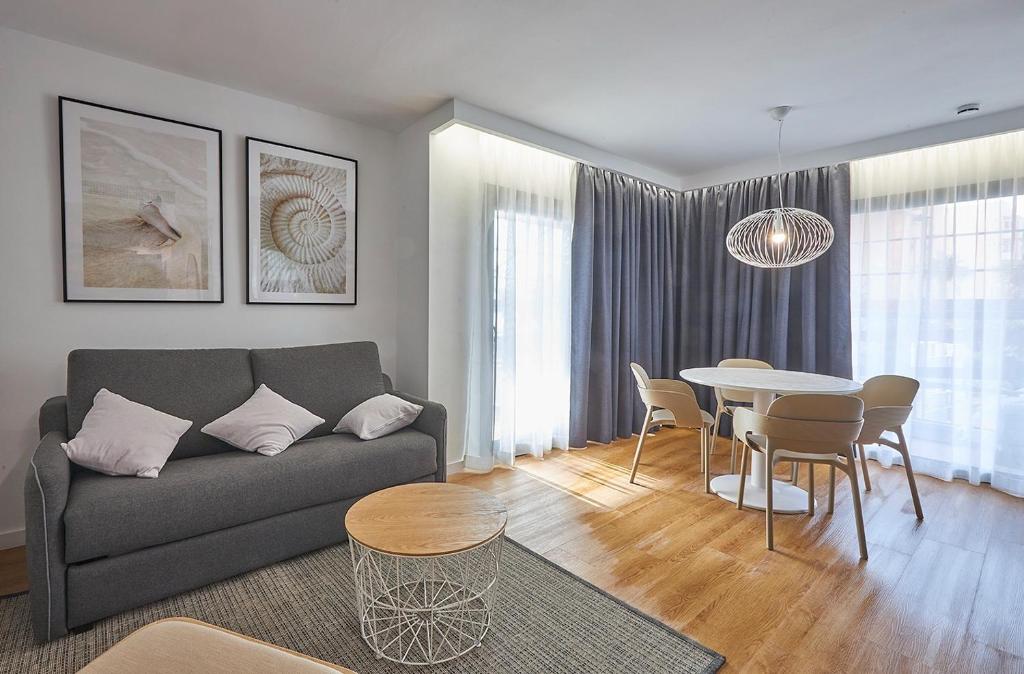 ein Wohnzimmer mit einem Sofa und einem Tisch in der Unterkunft Rentalmar Suites Salou Families Only in Salou