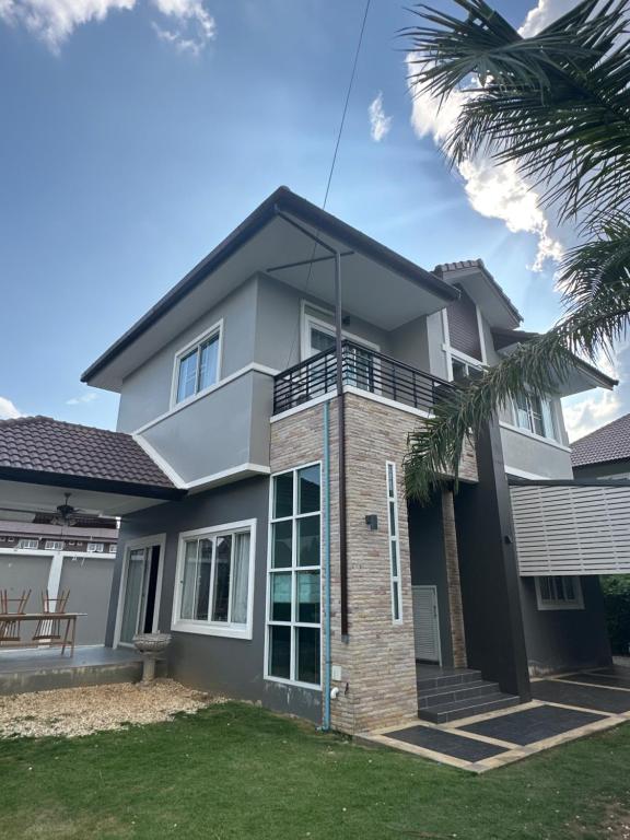 a house with a palm tree in front of it at Anne的小窝 in Ban Chang Kham Luang