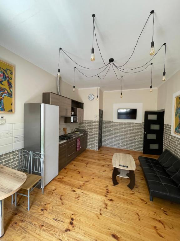 a kitchen and living room with a couch and a table at SWEET hostel in Vinnytsya