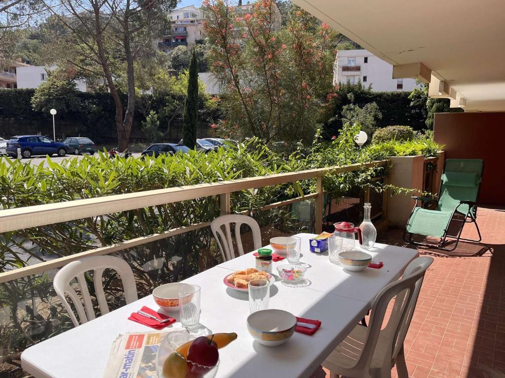 - une table blanche avec de la nourriture sur le balcon dans l'établissement Appt 3 pièces avec piscine proche centre ville, 4 couchages, Saint-Raphaël - FR-1-226A-144, à Saint-Raphaël