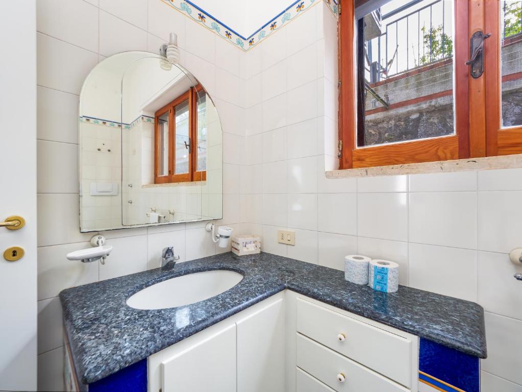 łazienka z umywalką i lustrem w obiekcie Villa Cristina - De Vivo Realty Piano di Sorrento w mieście Piano di Sorrento