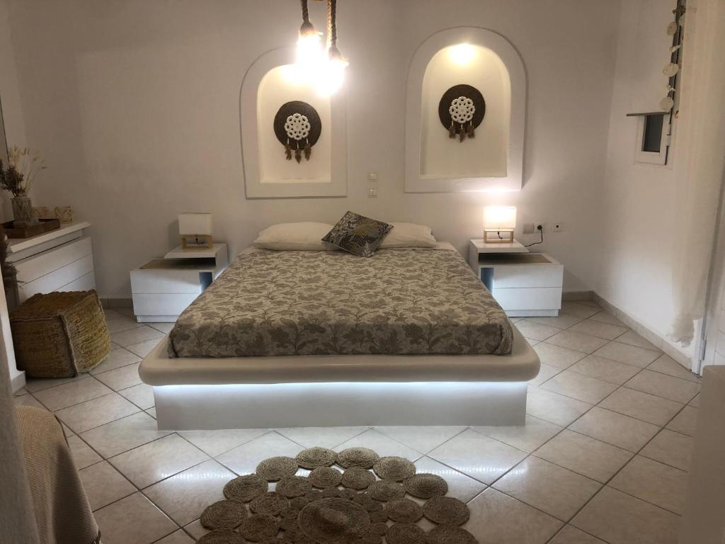 a bedroom with a large bed and two tables at Francesca Secret in Mikonos