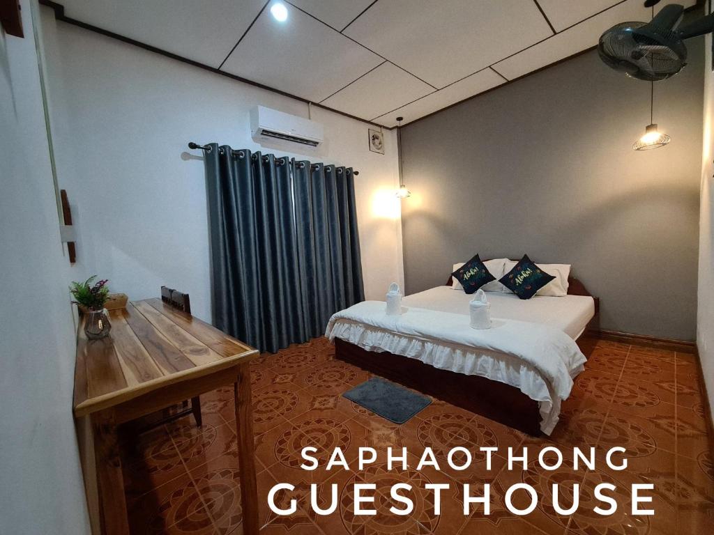 a hotel room with a bed and a window with the words syndrome questionnaire at Saphaothong guesthouse in Vang Vieng