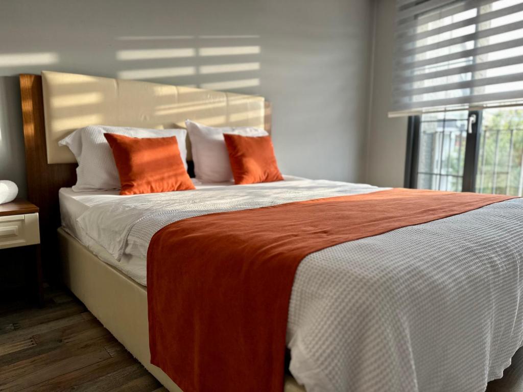 UğurluにあるSuitesのオレンジ色の枕が付いた大きなベッドのある寝室