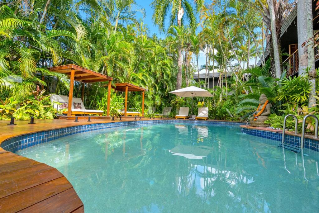 - une grande piscine dans un complexe avec des palmiers dans l'établissement The Palms At Palm Cove, à Palm Cove