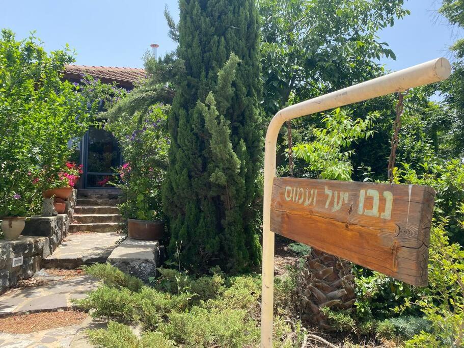 a wooden sign in front of a house at חצר ברמה in Sha'al