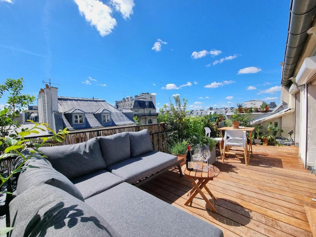 sala de estar con sofá en una terraza de madera en Sunny Terrace in Modern Flat with AC, en París