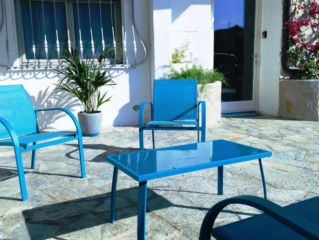 two blue chairs and a table on a patio at Casa Relax Diano Castello in Diano Castello