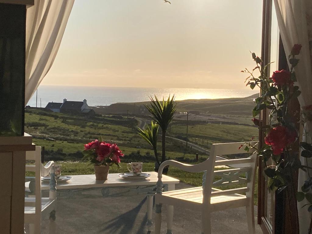 a table and chairs with a view of the ocean at West Horizon holiday cottage in Lochinver