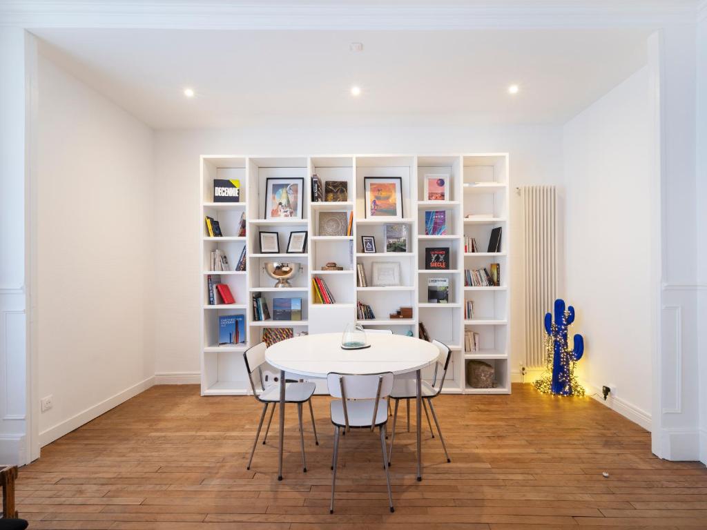 a white dining room with a white table and chairs at Le chic de Patton avec jardin privatif ! in Nancy