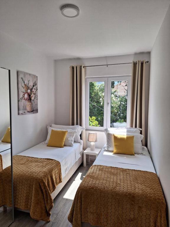 2 camas en una habitación con 2 ventanas en Apartment Ivy en Mlini