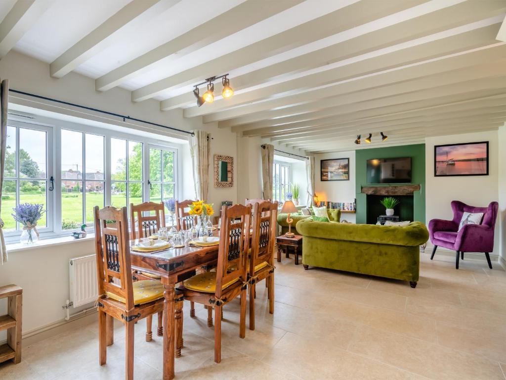 a dining room with a table and chairs and a couch at Seascape Cottage in South Creake