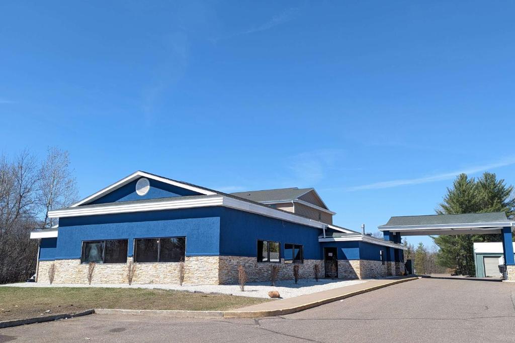 a blue building in front of a gas station at AmericInn by Wyndham Tomahawk in Tomahawk