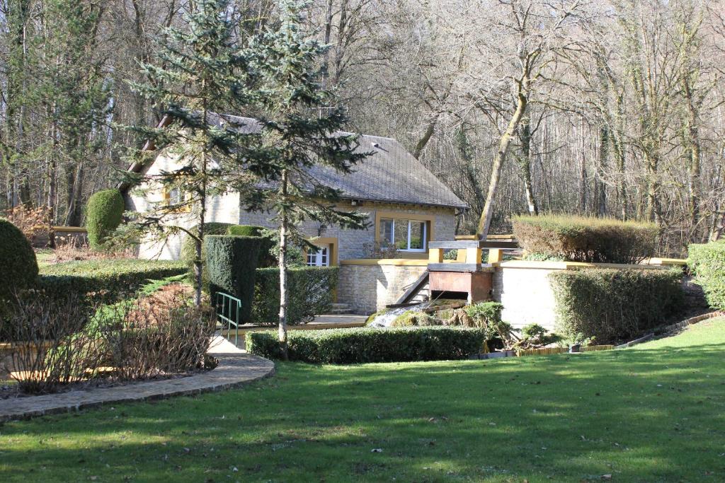 ein Haus inmitten eines grünen Gartens in der Unterkunft Le Moulin in Matton-et-Clémency