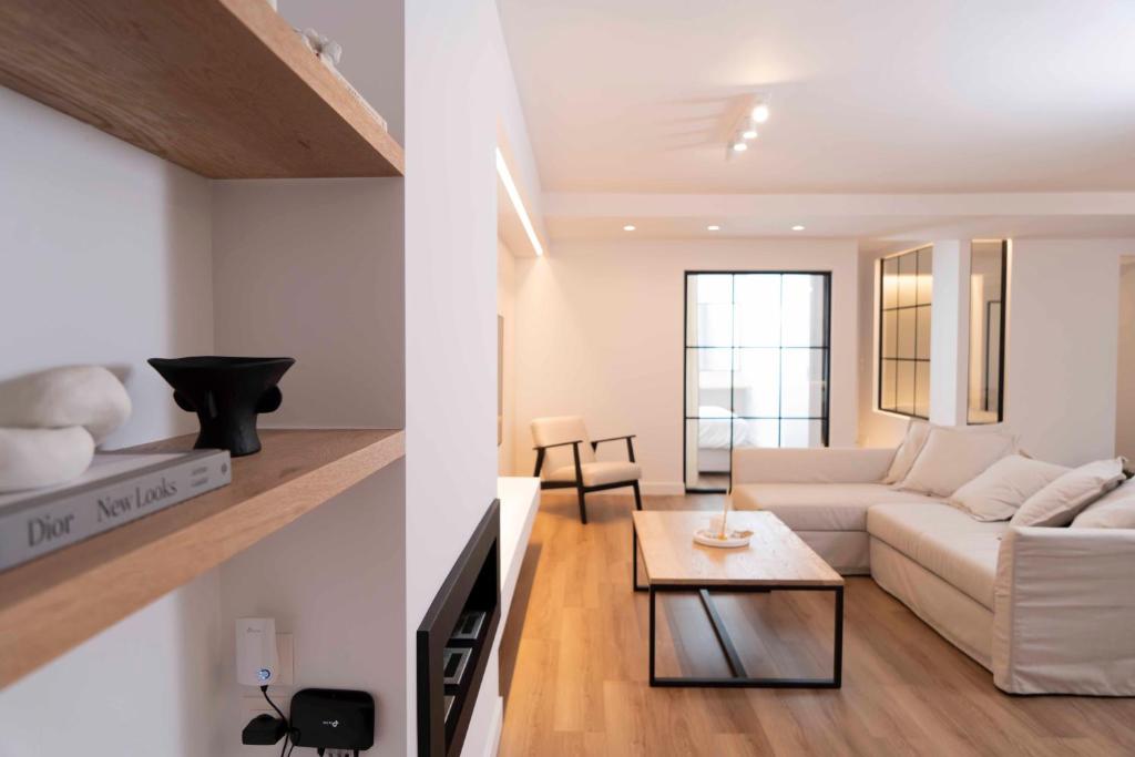 een woonkamer met een witte bank en een tafel bij Underground Luxury Living in Karistos