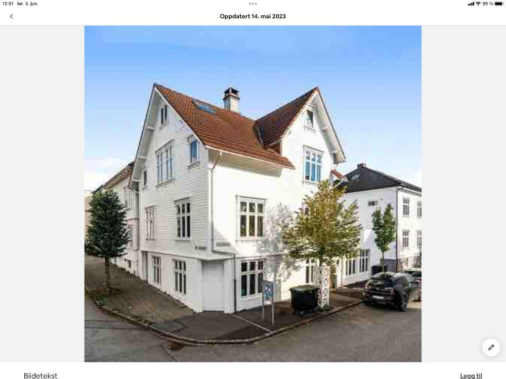 a large white house with a brown roof at Large & Cozy Stavanger Apt in Stavanger