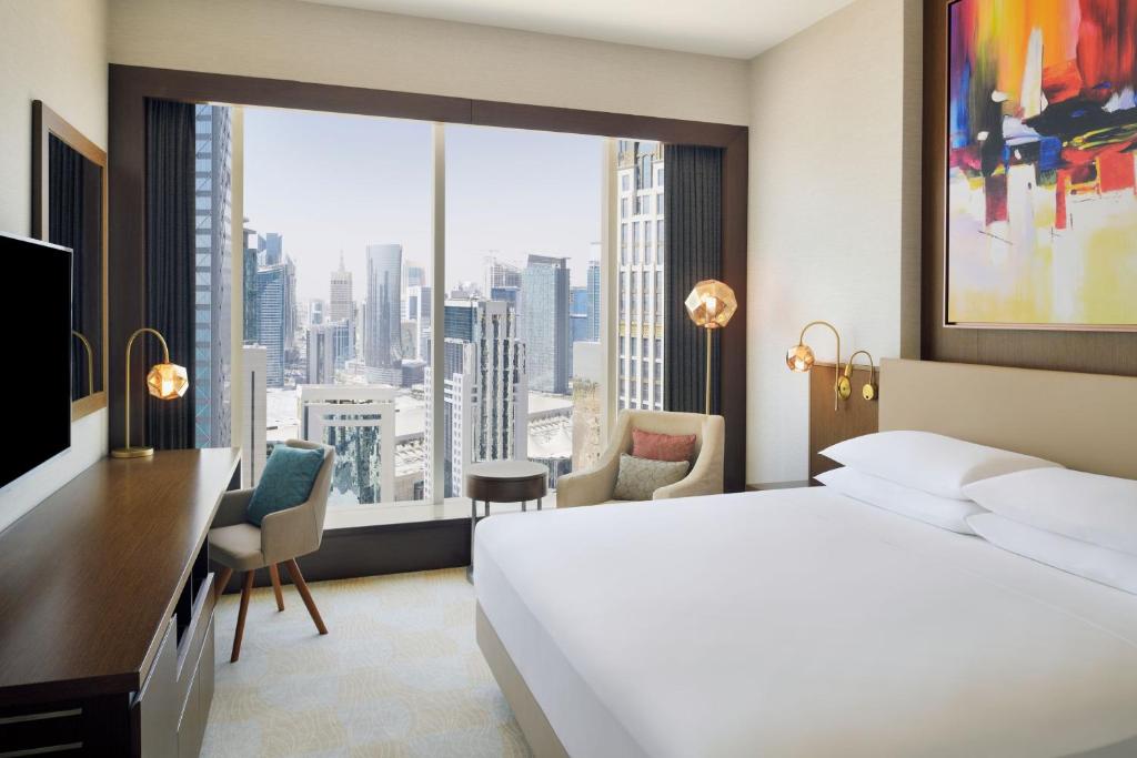 a hotel room with a bed and a large window at Delta Hotels by Marriott City Center Doha in Doha