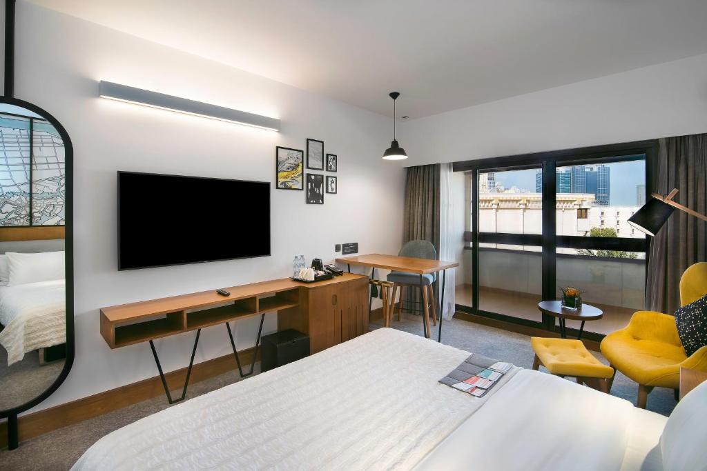 a hotel room with a bed and a flat screen tv at Le Meridien Abu Dhabi in Abu Dhabi