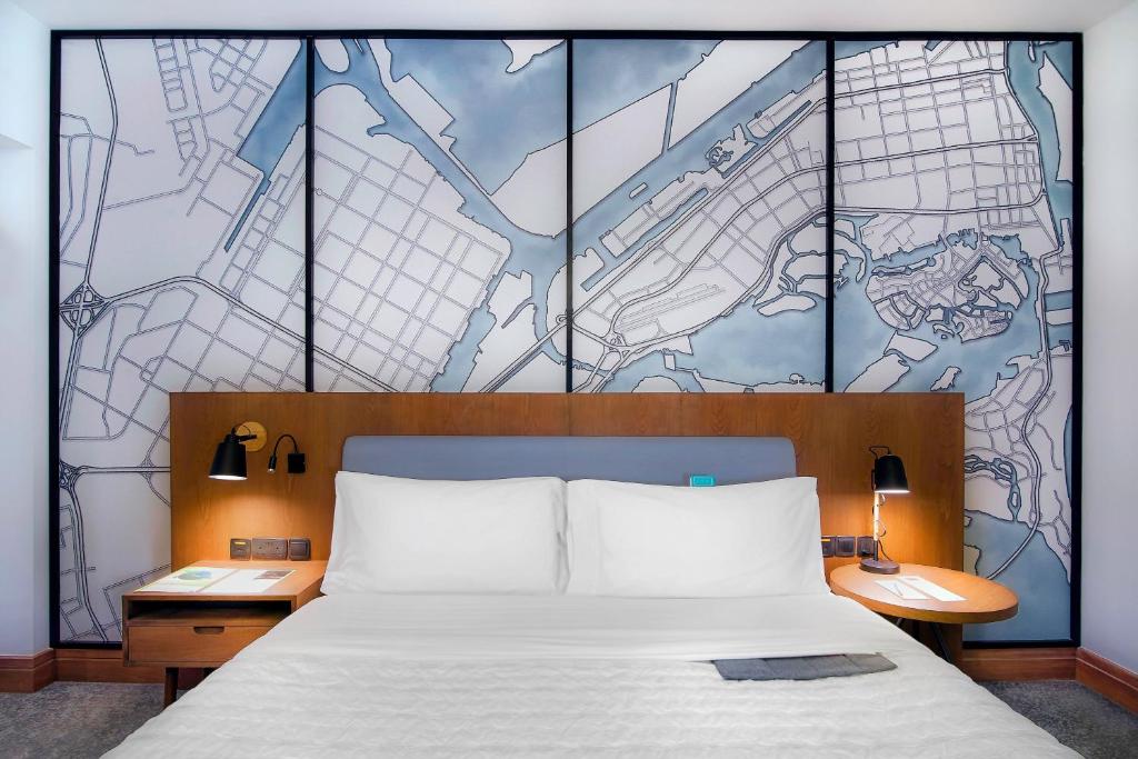 a bedroom with a bed with a map on the wall at Le Meridien Abu Dhabi in Abu Dhabi
