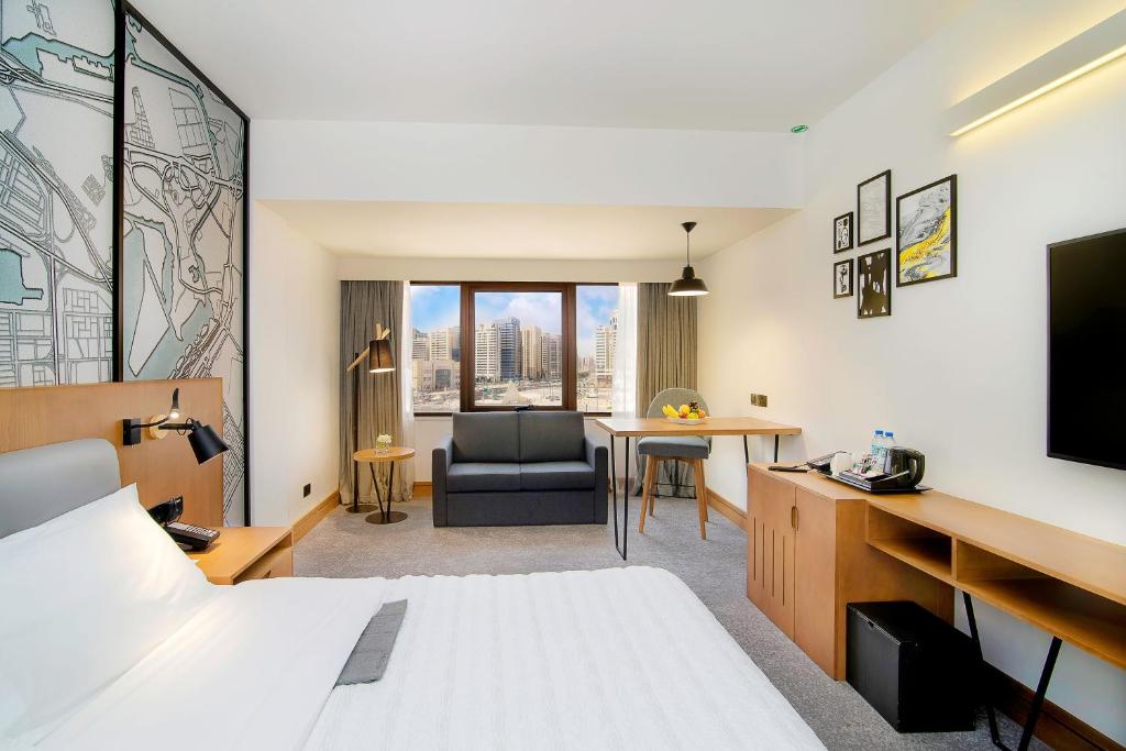 a hotel room with a bed and a desk at Le Meridien Abu Dhabi in Abu Dhabi