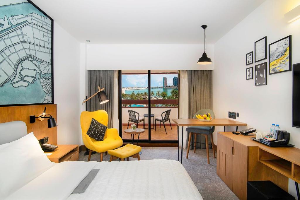 a room with a bed and a table and chairs at Le Meridien Abu Dhabi in Abu Dhabi