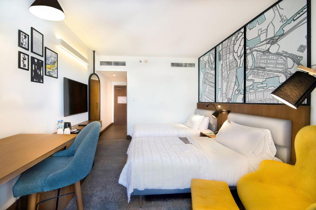 a hotel room with two beds and a desk at Le Meridien Abu Dhabi in Abu Dhabi