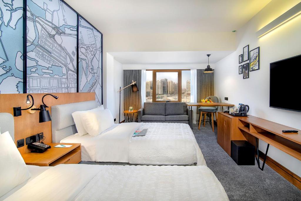 a hotel room with two beds and a flat screen tv at Le Meridien Abu Dhabi in Abu Dhabi