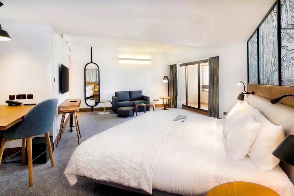 a hotel room with a large bed and a desk at Le Meridien Abu Dhabi in Abu Dhabi