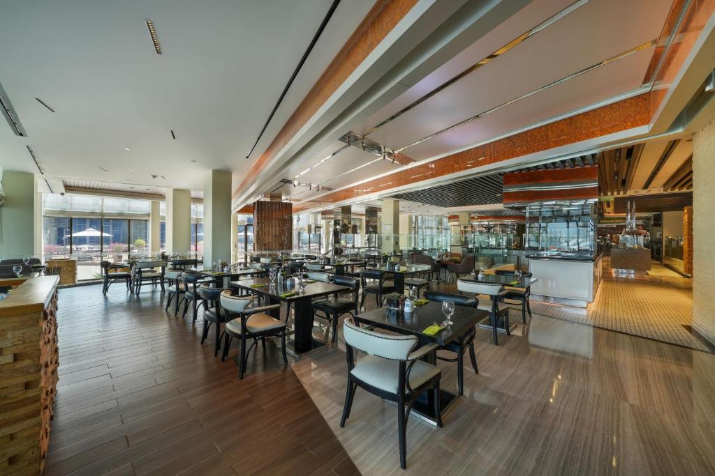 a dining room with tables and chairs in a restaurant at Le Meridien Abu Dhabi in Abu Dhabi