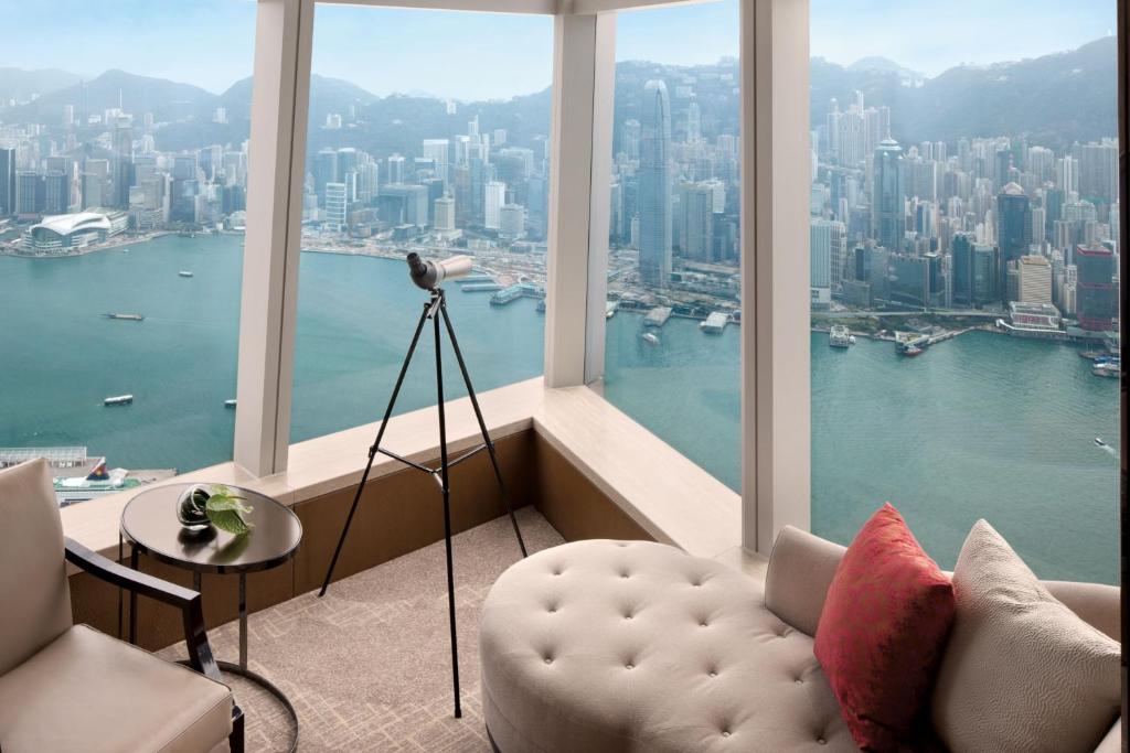 a living room with a view of a city at The Ritz-Carlton Hong Kong in Hong Kong