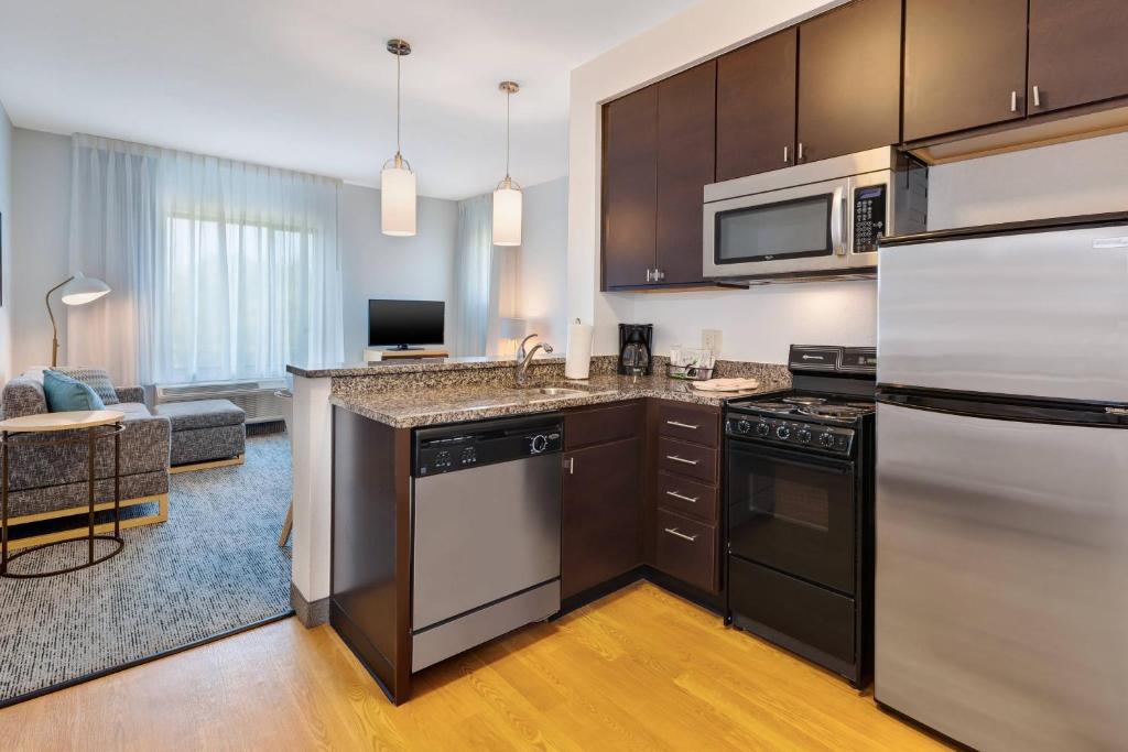 a kitchen with stainless steel appliances and a living room at TownePlace Suites by Marriott Nashville Airport in Nashville