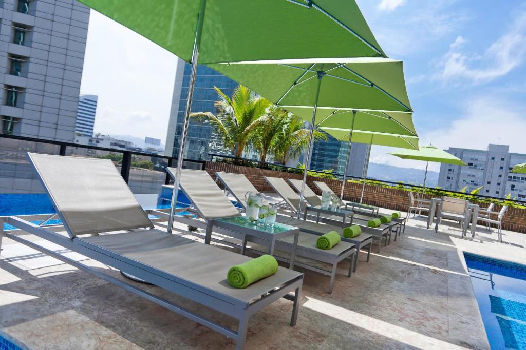 a row of lounge chairs and umbrellas on a rooftop at Renaissance Caracas La Castellana Hotel in Caracas