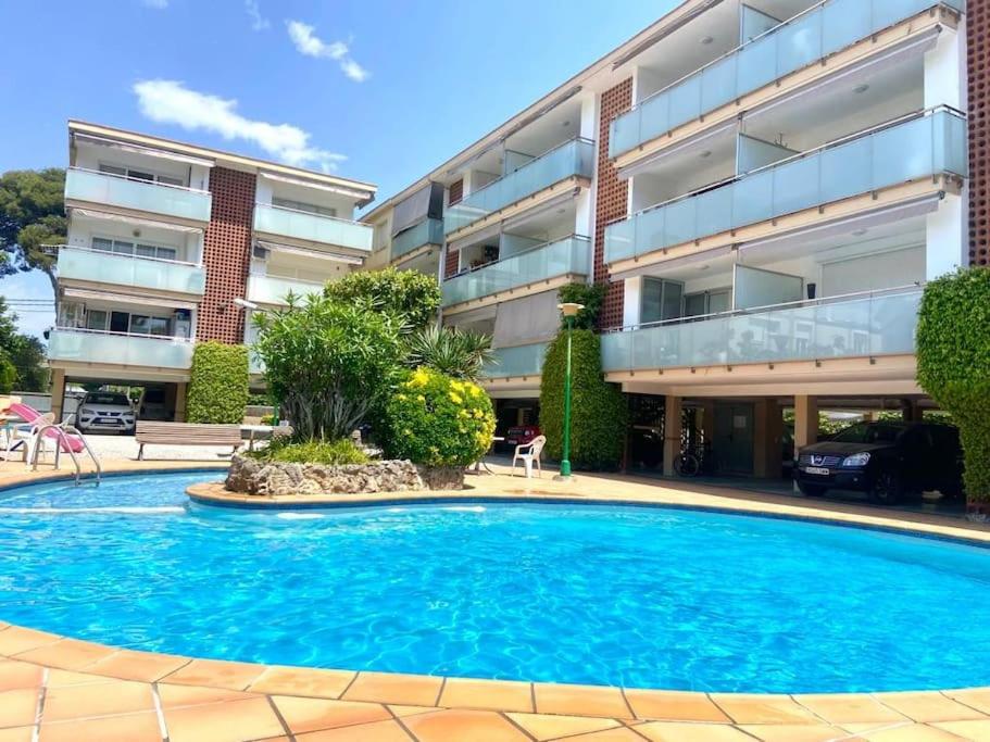 una gran piscina frente a un edificio en Precioso apartamento con piscina, en Castelldefels