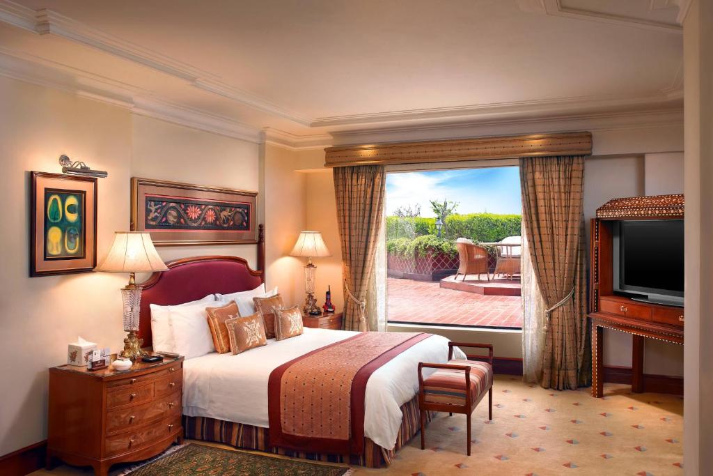 ITC Maurya, a Luxury Collection Hotel, New Delhi في نيودلهي: غرفة فندقية بسرير ونافذة كبيرة