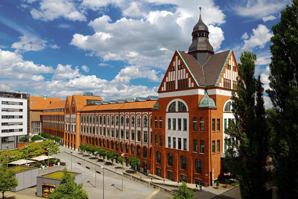 a large brick building with a tower on top of it at Sheraton Hannover Pelikan Hotel in Hannover