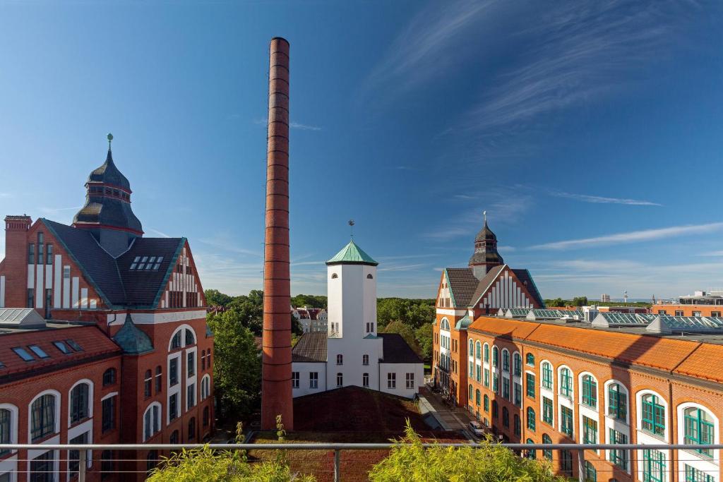 a group of buildings with a tall smoke stack at Sheraton Hannover Pelikan Hotel in Hannover