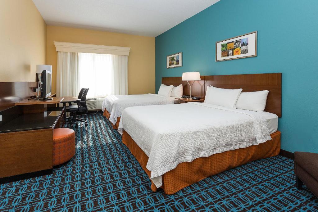 a hotel room with two beds and a desk at Fairfield Inn & Suites Des Moines West in West Des Moines