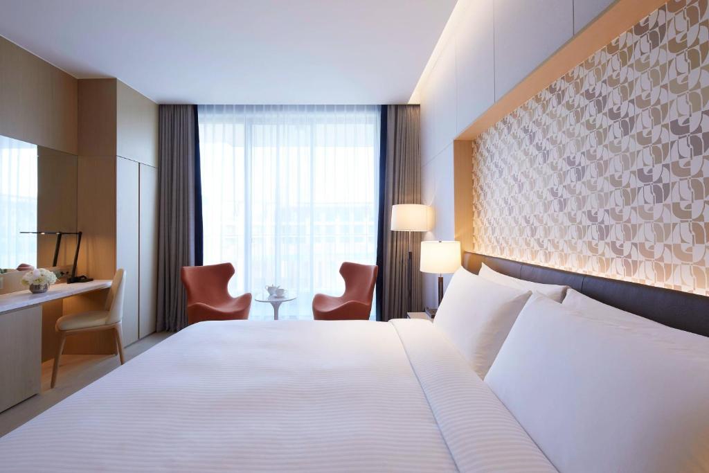 Postel nebo postele na pokoji v ubytování Marriott Jeju Shinhwa World Hotel