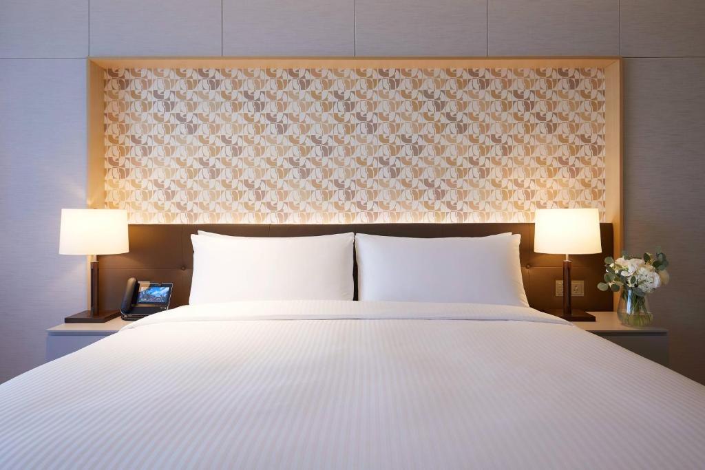 Postel nebo postele na pokoji v ubytování Marriott Jeju Shinhwa World Hotel