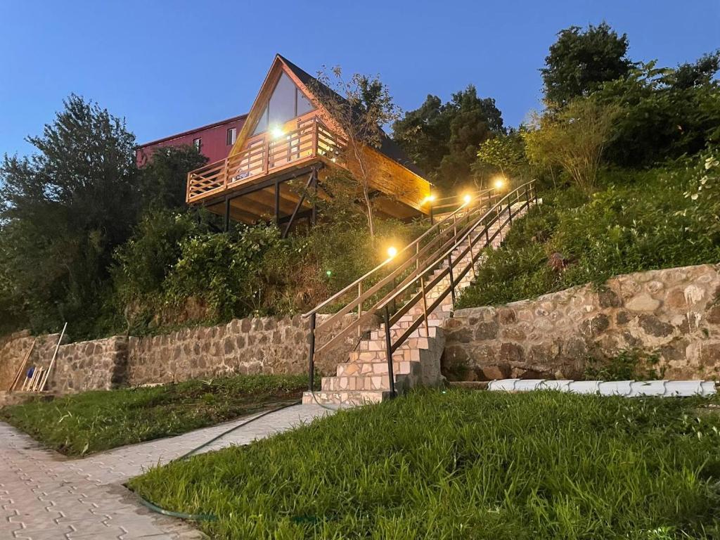 uma casa de madeira no topo de uma colina com escadas em Beautiful Wooden house with seaside views em Batumi
